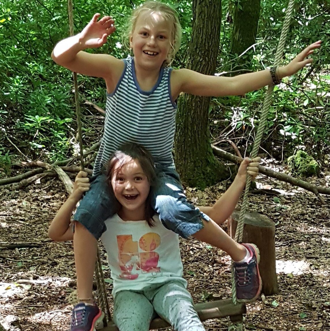children playing on a swing in the woods with the SHAC